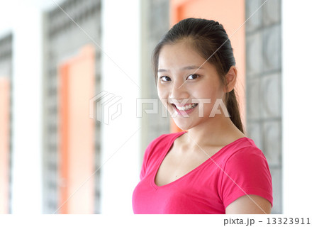 Portrait of one young pan asian female student along campus corridor 13323911