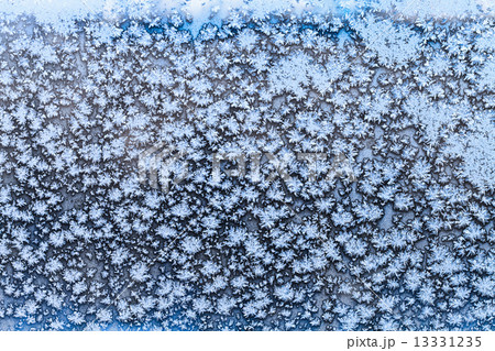 snowflakes and frost pattern on frozen window pane 13331235