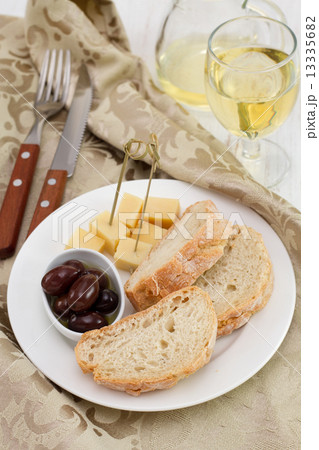 bread with cheese and olives on the plate 13335682