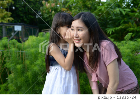 Mother and daughter sharing a secret 13335724