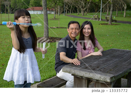 Family of 3 having fun in the park Family of 3 having fun in the park 13335772
