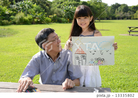 Grandfather and granddaughter relaxing in the park Grandfather and granddaughter relaxing in the park 13335802
