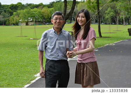 Aging father and daughter strolling in the park 13335836