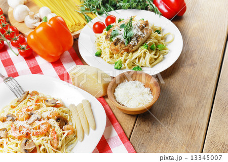 Pasta with shrimps and mashrooms on the wooden table Pasta with shrimps and mashrooms on the wooden table 13345007
