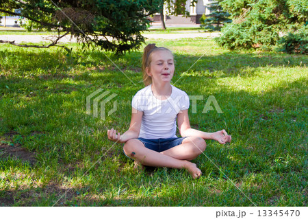 Cute girl in lotus pose with sore knee Cute girl in lotus pose with sore knee 13345470