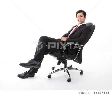 Man relaxing sitting on office chair looking forward Man relaxing sitting on office chair looking forward 13348131
