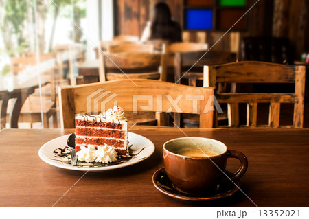Coffee cup with slice of cake on wood table in cafe Coffee cup with slice of cake on wood table in cafe 13352021