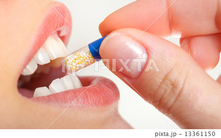 young woman holding pill 13361150