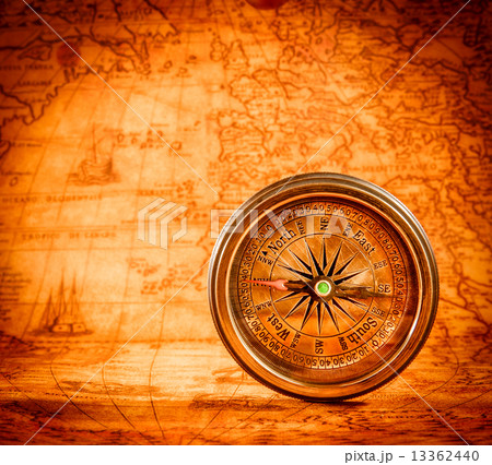 Vintage compass lies on an ancient world map. 13362440