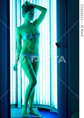 Young woman sunbathing in solarium Young woman sunbathing in solarium 13363612