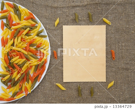 Raw three-colored Italian pasta on a sackcloth Raw three-colored Italian pasta on a sackcloth 13364729