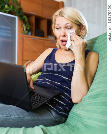 Woman crying while using laptop Woman crying while using laptop 13370450