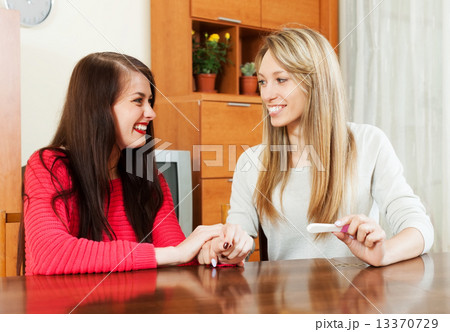 Happy young women with pregnancy test Happy young women with pregnancy test 13370729