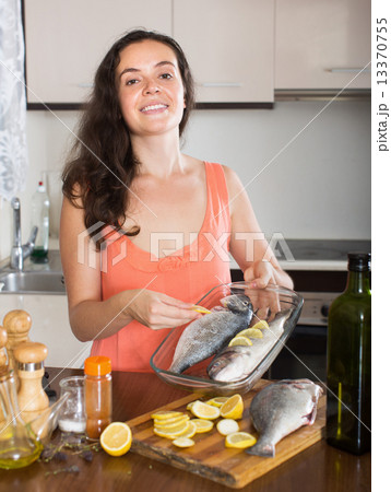 Happy housewife preparation fish in frying pan Happy housewife preparation fish in frying pan 13370755