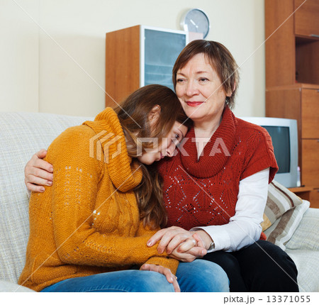 Mature woman comforting crying adult daughter Mature woman comforting crying adult daughter 13371055