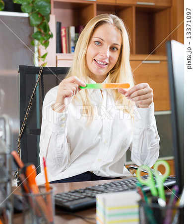 woman doing manicure at office woman doing manicure at office 13371097