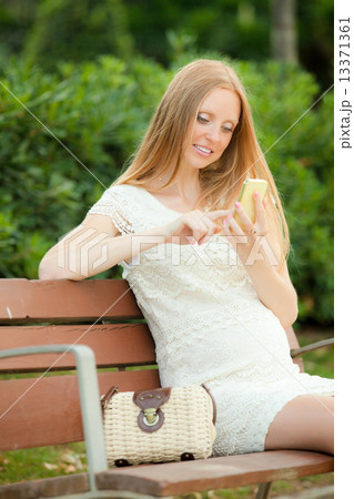 pregnant woman ringing a mobile in the summer park pregnant woman ringing a mobile in the summer park 13371361
