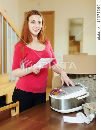 cheerful woman reading guarantee card cheerful woman reading guarantee card 13371390