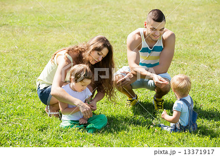 Family of four in sunny park Family of four in sunny park 13371917