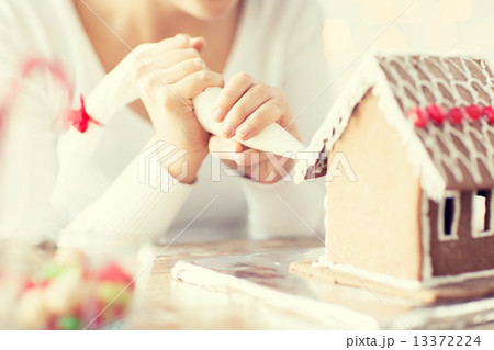 close up of woman making gingerbread house at home 13372224