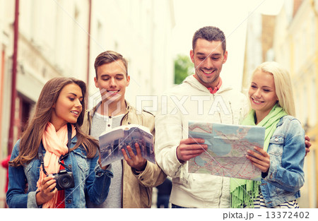 group of friends with city guide, map and camera 13372402