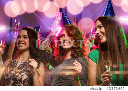 smiling friends with glasses of champagne in club smiling friends with glasses of champagne in club 13372462