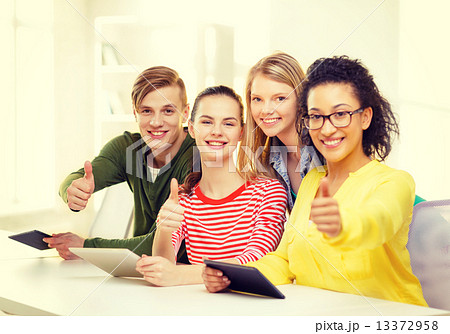 smiling students with tablet pc at school 13372958