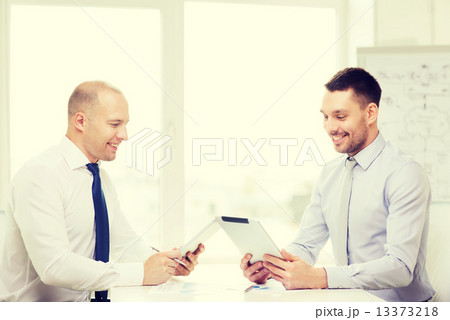 two smiling businessmen with tablet pc in office 13373218