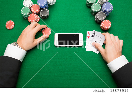 casino player with cards, smartphone and chips 13373915