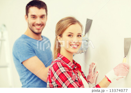 smiling couple doing renovations at home smiling couple doing renovations at home 13374077