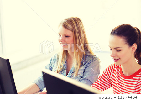 two smiling girls in computer class two smiling girls in computer class 13374404
