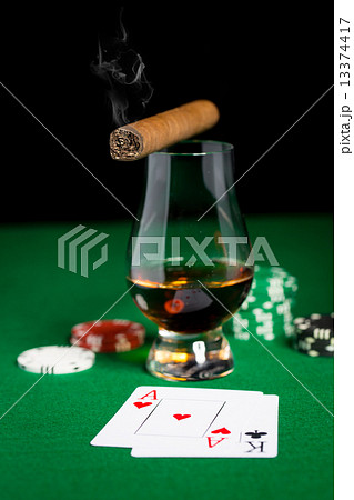 close up of chips, cards whisky and cigar on table close up of chips, cards whisky and cigar on table 13374417