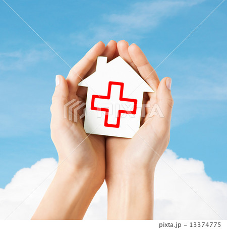 hands holding paper house with red cross hands holding paper house with red cross 13374775