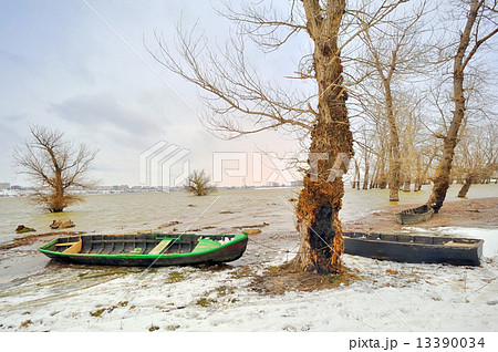 green boat on shore in winter 13390034