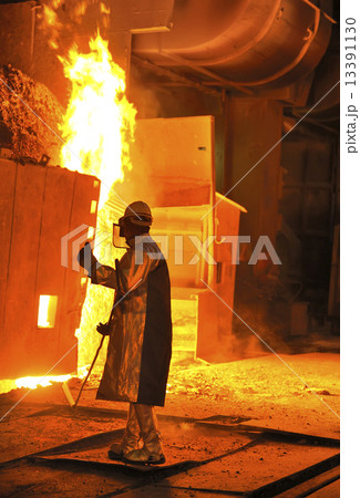 A steel worker takes a sample from oven 13391130