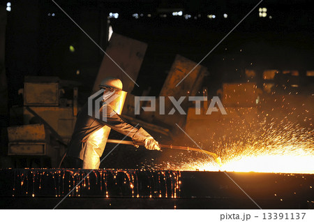 worker using torch cutter to cut through metal 13391137