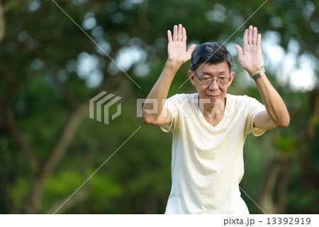 One male chinese elderly doing morning exercise in a park 13392919