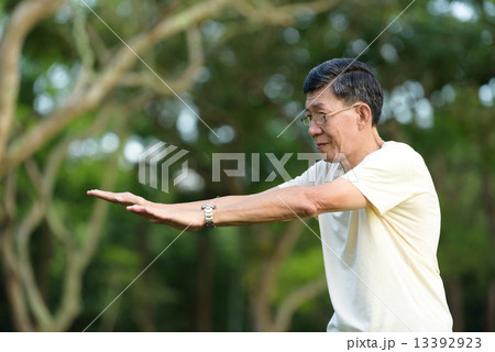 One male chinese elderly doing morning exercise in a park 13392923