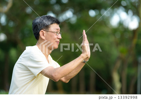 One male chinese elderly doing morning exercise in a park 13392998