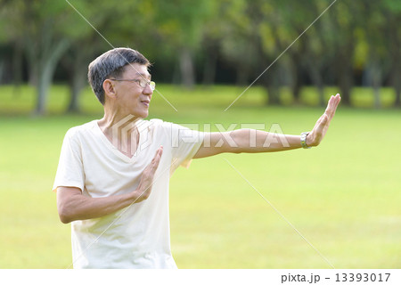 One male chinese elderly doing morning exercise in an open field in the park 13393017