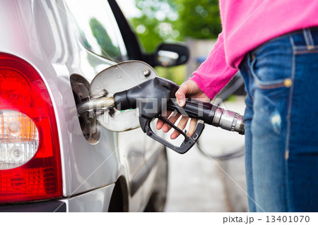 Lady pumping gasoline fuel in car at gas station. 13401070