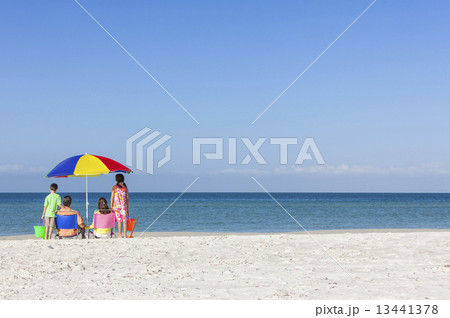 Family Alone on Beach With Umbrella Family Alone on Beach With Umbrella 13441378