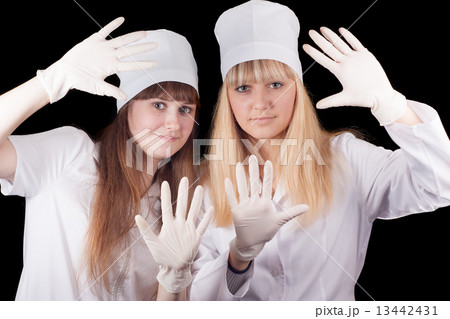 Two nurses in uniform on a black background. 13442431