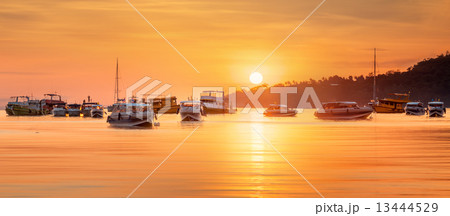sunrise with colorful sky and boats on the beach 13444529