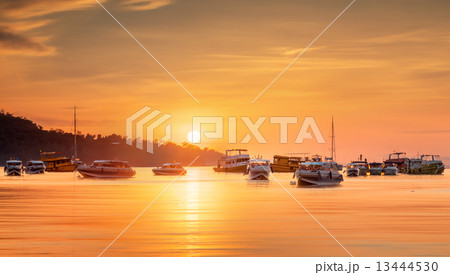 sunrise with colorful sky and boats on the beach 13444530