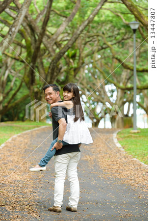 Chinese father piggy back daughter in the park Chinese father piggy back daughter in the park 13447807