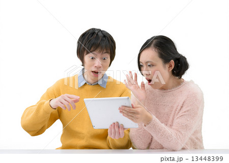 タブレットを操作している20代カップルの白抜きポーズ 13448399