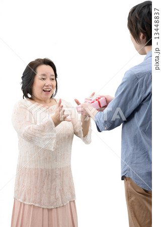 記念日に母親にプレゼントを贈る20代の息子の白抜きポーズ写真 13448837