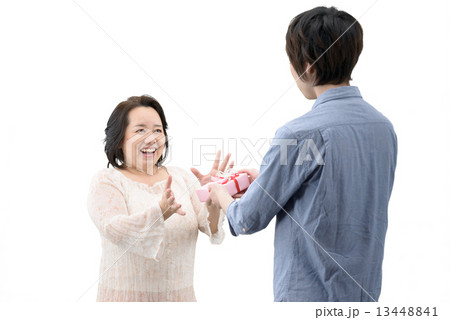 記念日に母親にプレゼントを贈る20代の息子の白抜きポーズ写真 13448841