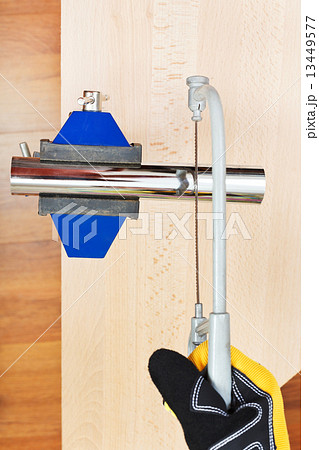 metalworker sawing trap pipe gripped in vice 13449577